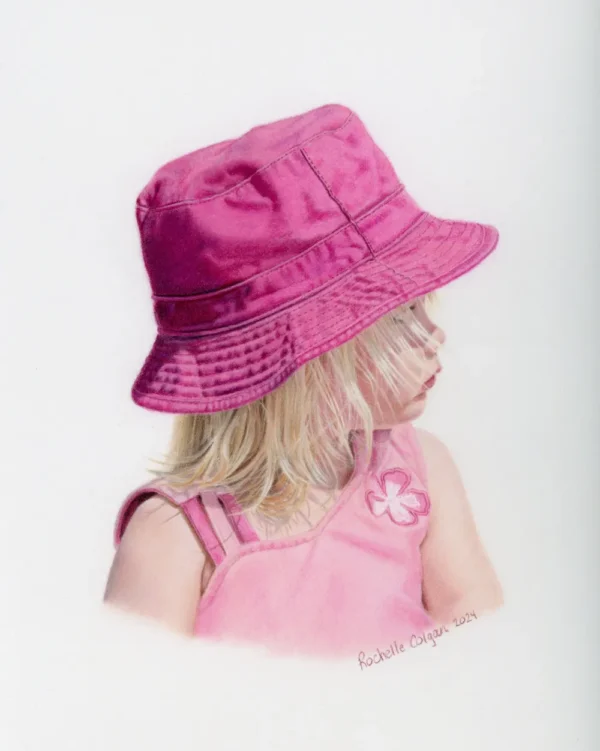 Realistic custom portrait of a two year old girl looking to the side, wearing a pink bucket hat and pink shirt. By Alberta artist Rochelle Colgan