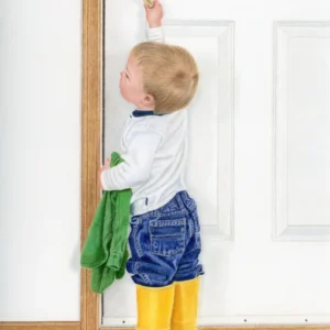 Realistic drawing of a 2 year old boy with bright yellow rubber boots pulling down the handle to open a door to the outside. By Alberta artist Rochelle Colgan