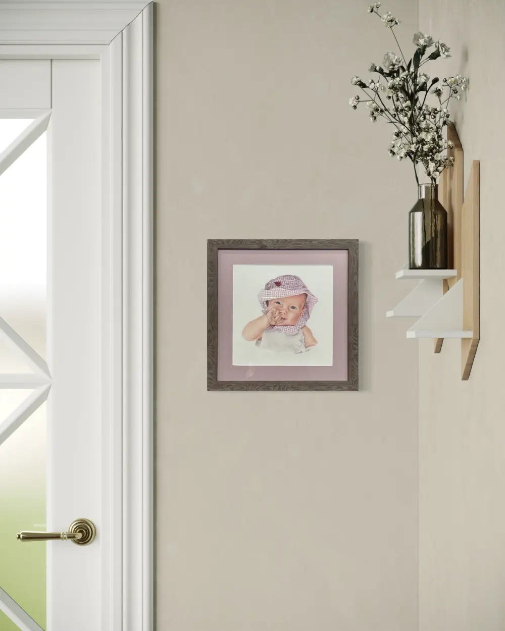 Framed realistic custom portrait of a three month old baby, wearing a gingham pink and white bucket hat and white shirt, hanging on a wall. By Alberta artist Rochelle Colgan