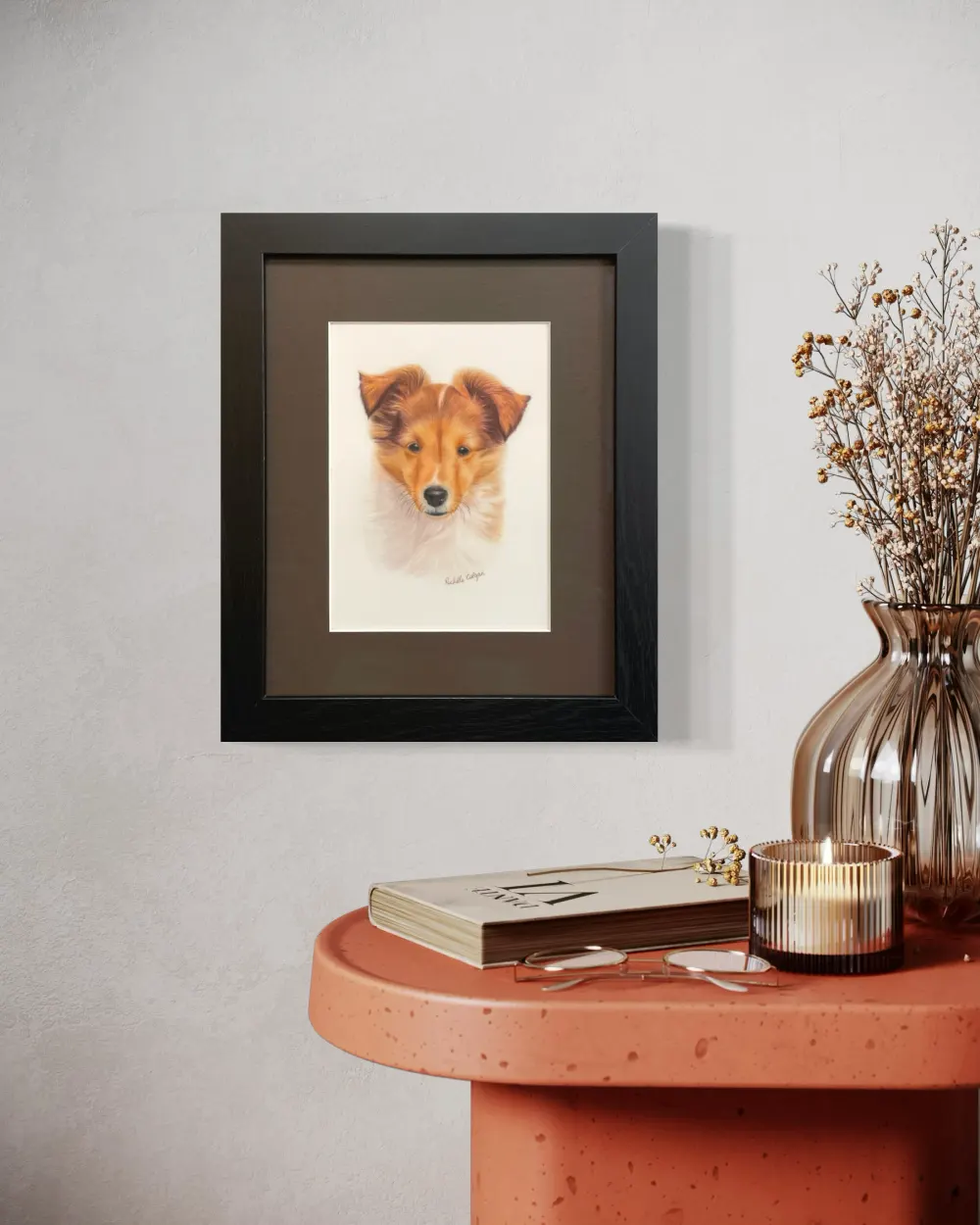 Framed realistic custom portrait of Sheltie puppy head and chest, hanging on a wall. By Alberta artist Rochelle Colgan
