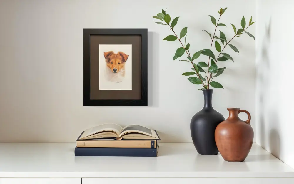 Framed realistic custom portrait of Sheltie puppy head and chest, hanging on a wall. By Alberta artist Rochelle Colgan